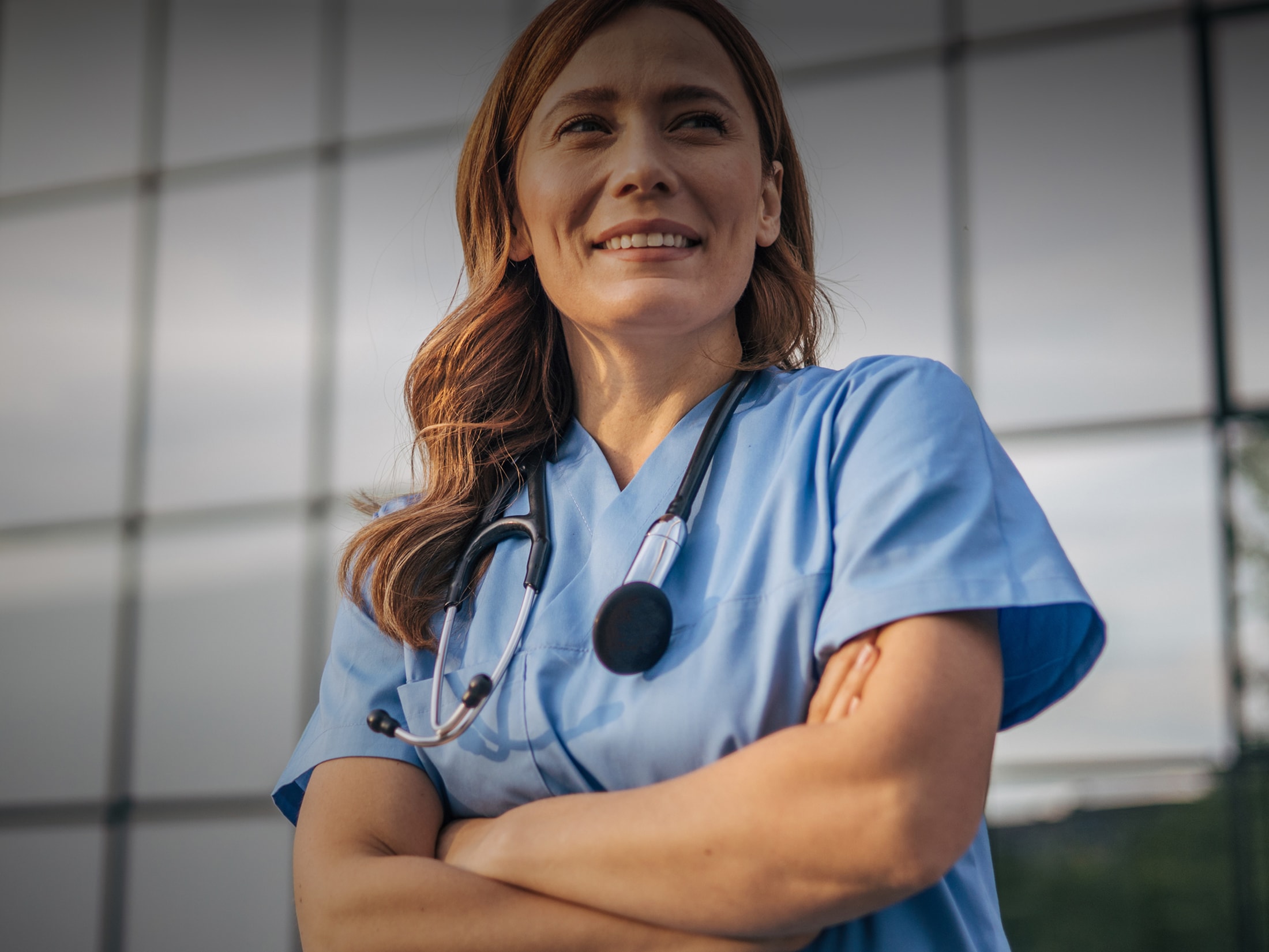 Smiling healthcare professional in blue scrubs.