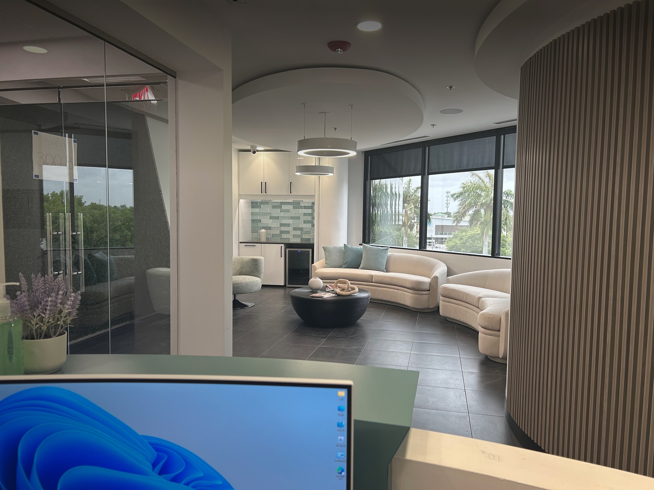 Modern office lounge with seating and windows.